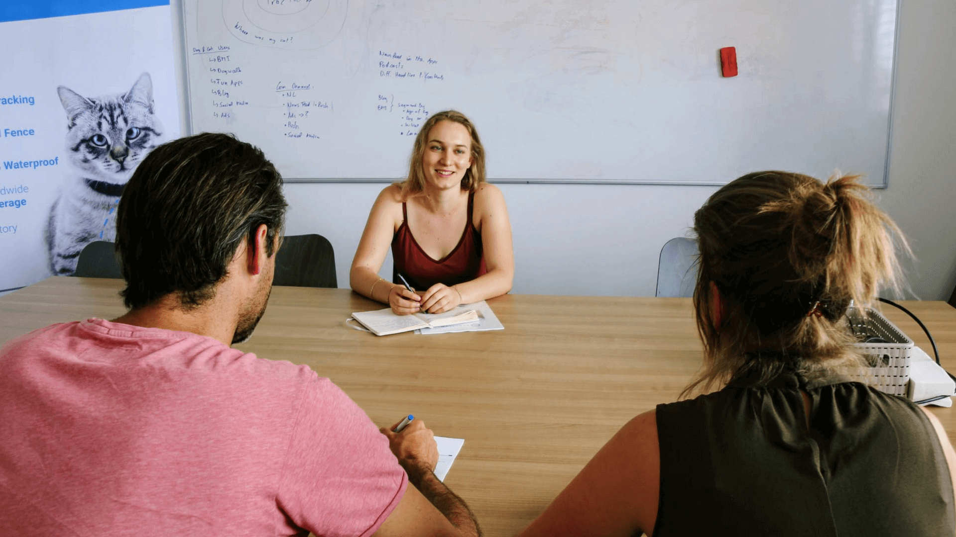 Three people sitting at a table in an office